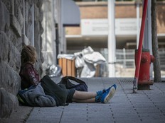 A person sleeps in a shady spot on the street in Montreal's Chinatown.