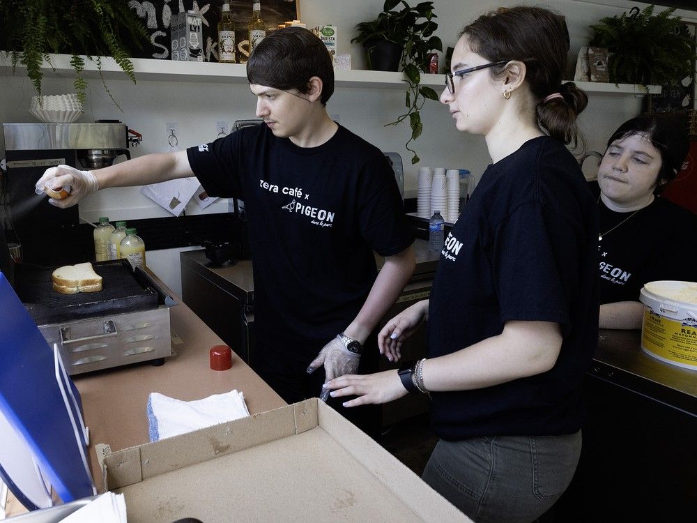 Alexandru Ionescu prepares a grilled cheese sandwich as Lindsay Oksenberg, right, and assistant job coach Elana Warshawsky look on at  Pigeon dans le Parc in Hampstead Park on Tuesday, July 2, 2024.