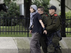 A protester is escorted by police.