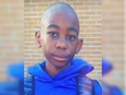 Photo of a 10-year-old black boy with a shaved head wearing a blue hoodie and a backpack