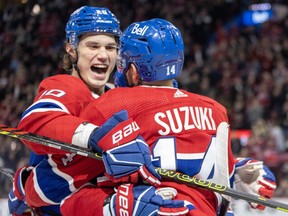 Canadiens' Juraj Slafkovsky, left, is seen with a big smil on his face as he hugs teammate Nick Suzuki after Suzuki scored a goal..