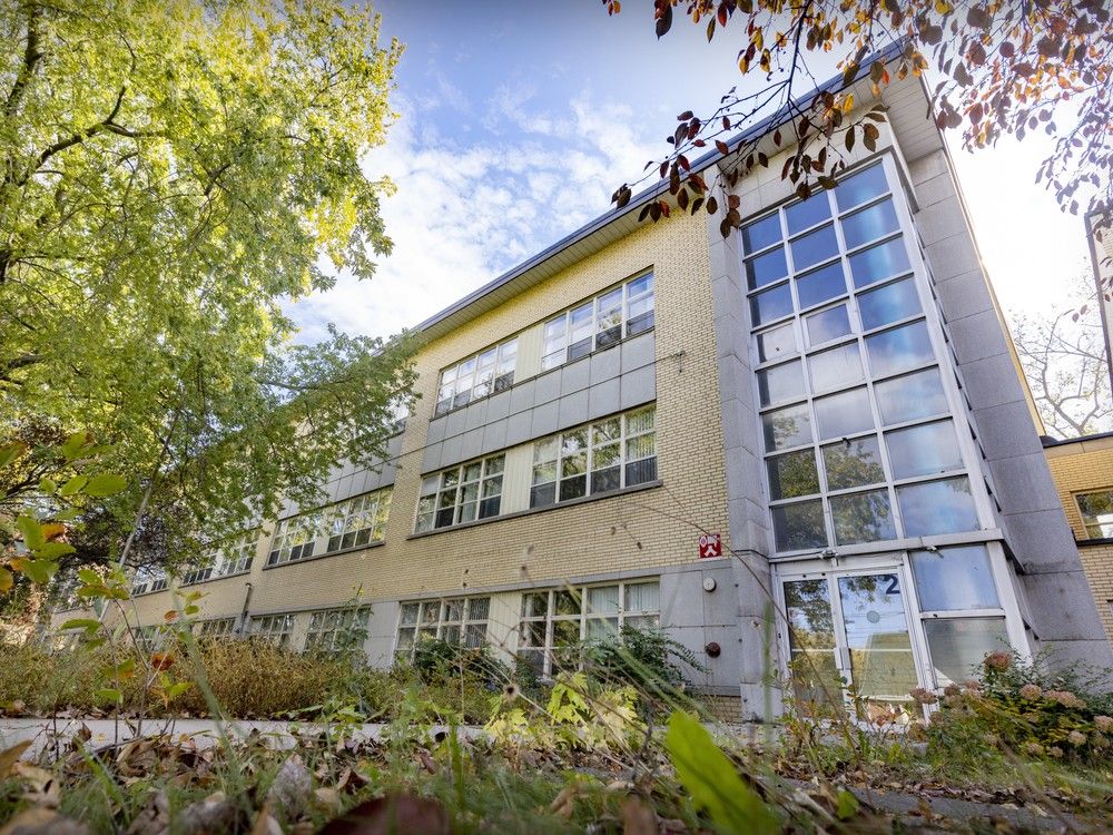 A side view of a building, with trees in the foreground.