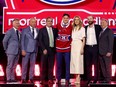 Seven people stand on stage, one wearing a Canadiens jersey