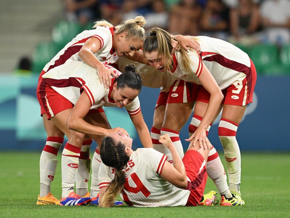 Team Canada's Vanessa Gilles (#14) celebrates with teammates after scoring her team's second goal to secure a win against France during Olympic Games action in St-Étienne, France.