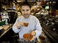 Café owner holds an expresso in his hands