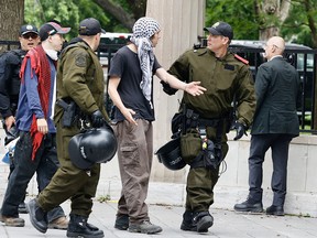 Uniformed officers escort a protester.