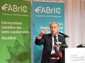 François-Philippe Champagne gestures while speaking at a microphone in front of banners advertising 'FABrIC'