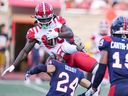 Alouettes defensive back Marc-Antoine Dequoy tackles Stampeders receiver Marken Michel during game at Molson Stadium last Saturday. Dequoy later left the game with an injury.