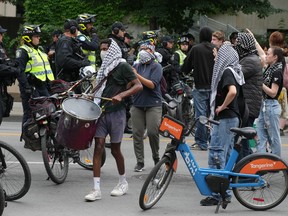 Protesters bang drums on a city street.