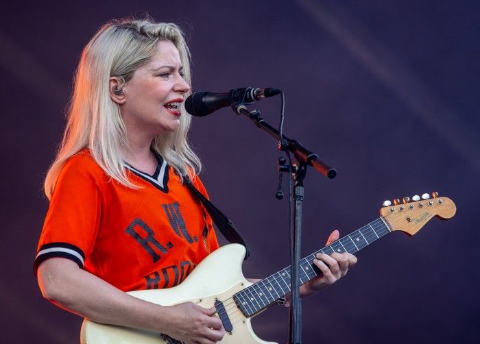 A woman sings while playing the guitar