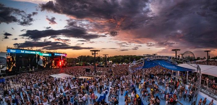 Wide-angle shot of a music festival at sunset