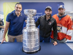 Former star goalie and now Panthers executive Roberto Luongo, left, poses with the Stanley Cup and his brothers Leo and Fabio, right, in St-Léonard on Wednesday.
