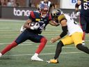 Alouettes' Charleston Rambo, left, tries to get around Hamilton Tiger-Cats' Jonathan Moxey in Montreal on Saturday, August 10, 2024.
