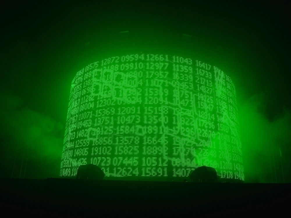 A cylindrical digital display shows a series of five-digit numbers in green script.