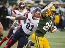 Alouettes' Sean Thomas-Erlington tries to tackle Elks running-back Javon Leake during game at Commonwealth Stadium.