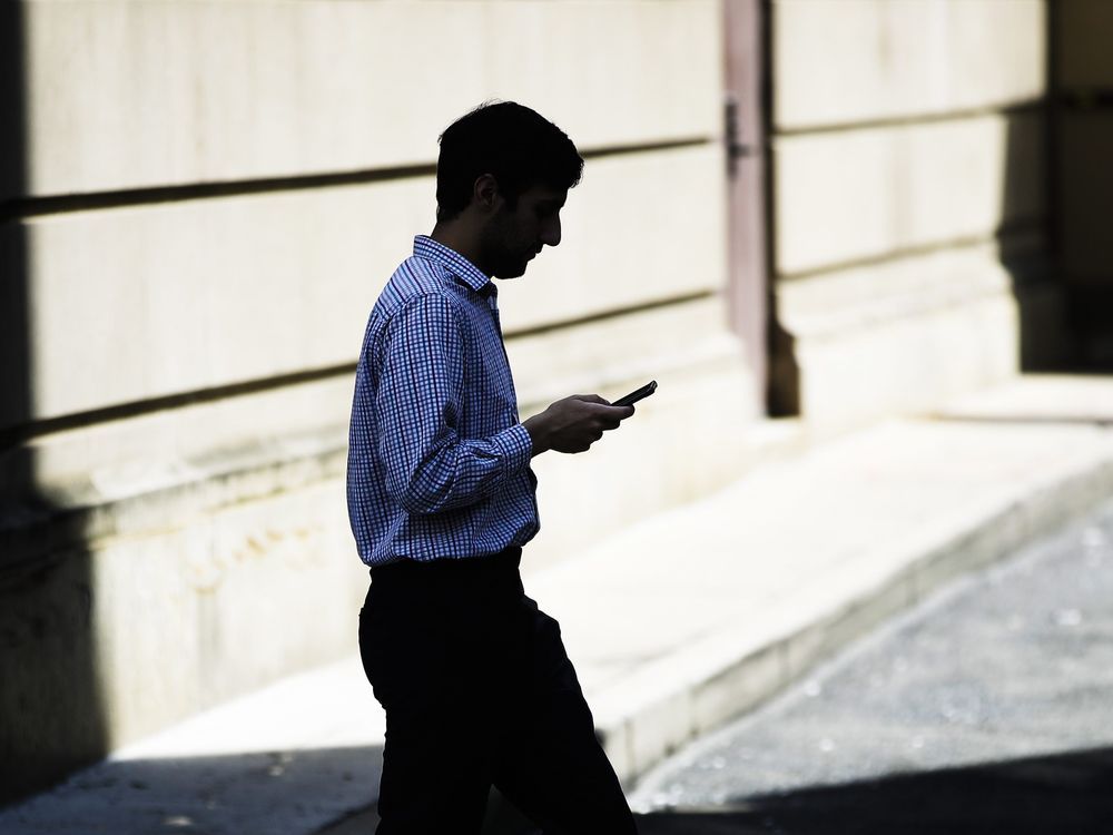 A Montreal man has been sentenced to 10 years in prison by a Pennsylvania judge for operating a telemarketing scheme that defrauded American seniors of millions of dollars. A man browses his smartphone as he walks in Philadelphia, Monday, April 8, 2019.