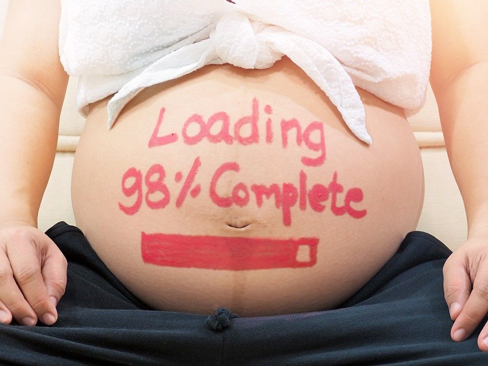 a pregnant belly with a progress bar in lipstick. over the bar it says: loading 98% complete