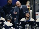 Coach Pascal Vincent talks with Jackets defenceman Jake Bean during a game last season.