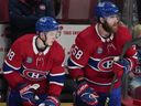 Canadiens' Lane Hutson, left, and David Savard watch the action during last game of the 2023-24 season in April. The two are paired as defence partners again this pre-season.