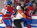 Flyers' Hunter McDonald (41) is checked by Canadiens' Luke Tuch (88) and Jared Davidson (76) during first period NHL pre-season action in Montreal on Monday, Sept. 23, 2024.