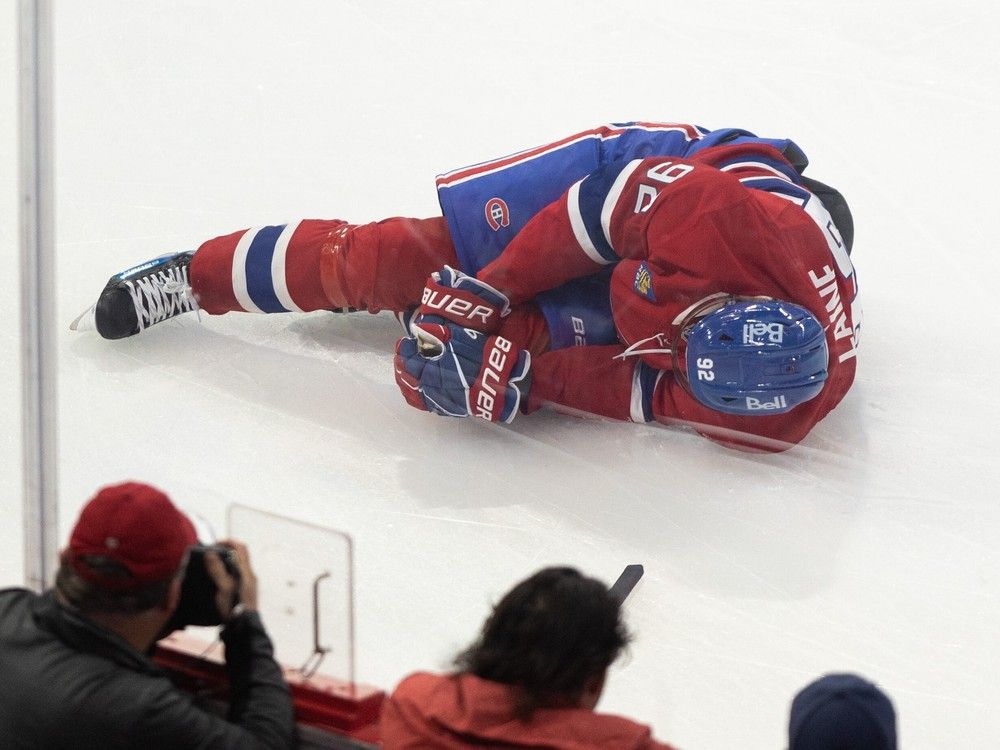 The Canadiens' Patrik Laine lies on the ice after taking a knee-on-knee hit from the Toronto Maple Leafs’ Cédric Paré during the first period of Saturday night’s NHL pre-season game at the Bell Centre.