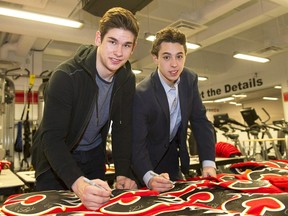 Calgary Flames' Johnny Gaudreau, right, and Sean Monahan sign team jerseys when they were both rookies in 2014.
