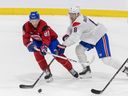 Joshua Roy, in red, is checked by Mike Matheson during Habs training camp in Brossard last month.