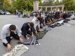 People pray outside McGill University's Roddick Gates during a pro-Palestinian protest