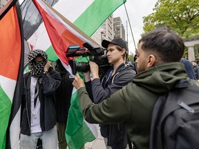 Pro-Palestinian protesters surround a TVA cameraman during protest outside McGill University