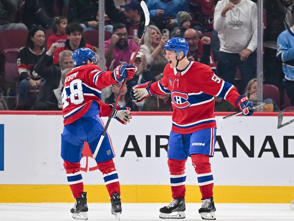 Canadiens' Emil Heineman (51), right, celebrates his first career NHL goal with teammate Lane Hutson (48) during the first period against the Ottawa Senators at the Bell Centre on Saturday, Oct. 12, 2024, in Montreal.