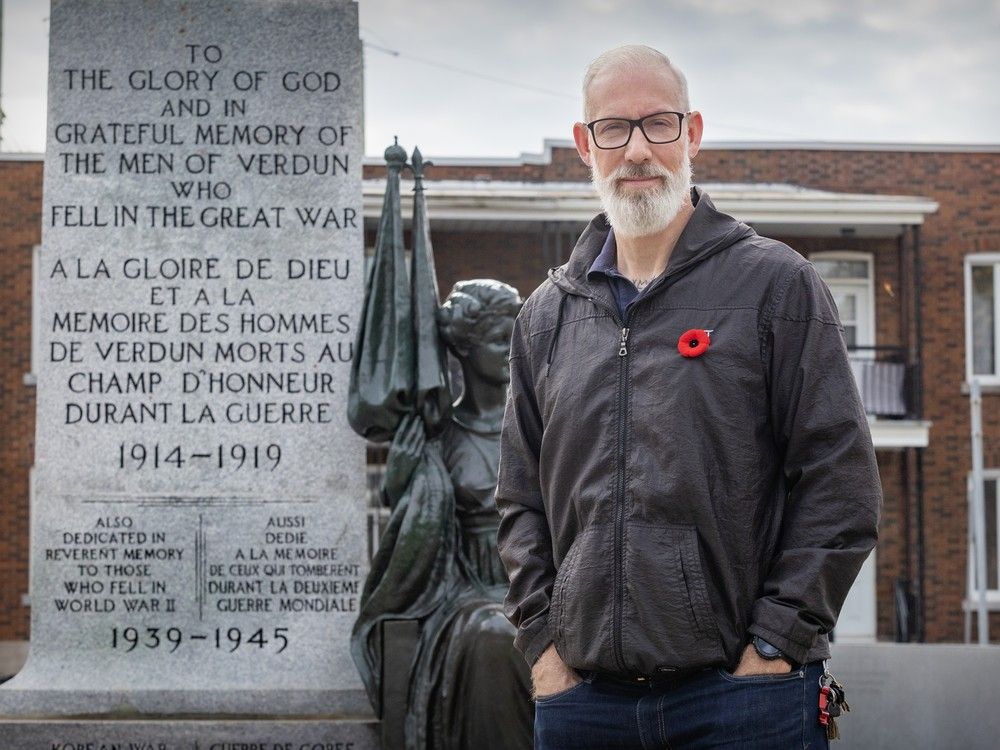 verdun city councillor sterling downey stands by the borough's cenotaph, wearing a remembrance day poppy pin.