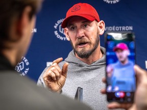 Jason Maas speaks at a news conference while being recorded on a journalist's cellphone