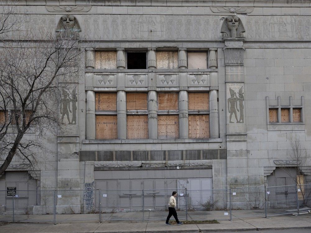 an old theatre building is boarded up with a fence in front of it