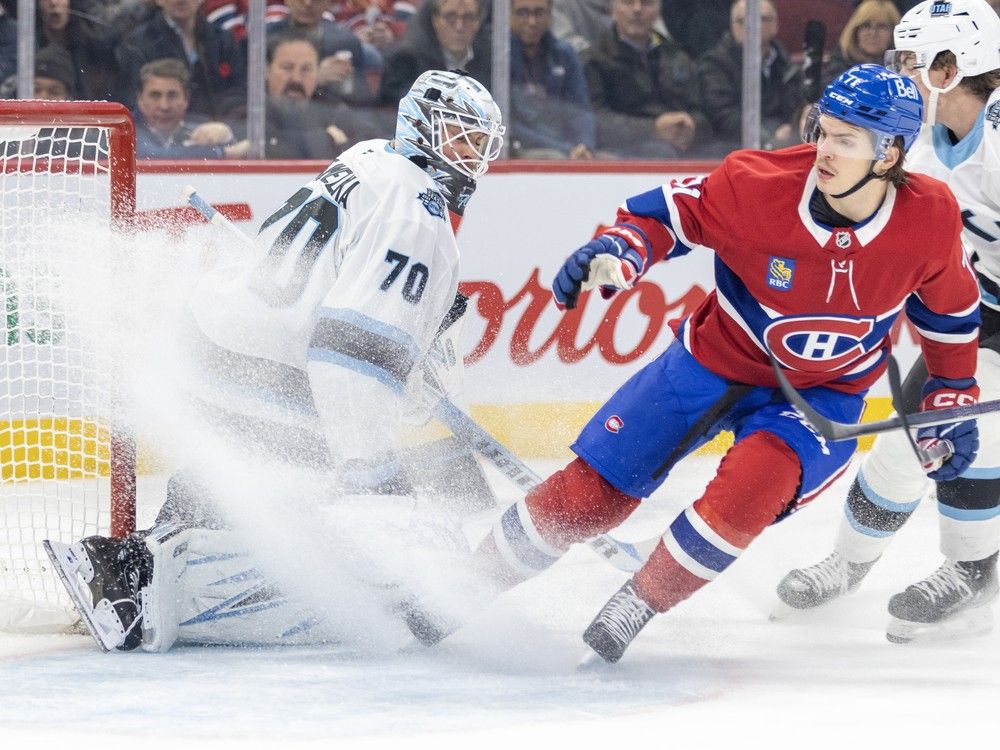 Montreal Canadiens' Jake Evans stops on the ice, sending a snow shower toward Utah Hockey Club's goalie Karel Vejmelka