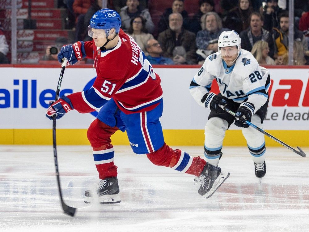 Canadiens' Emil Heineman has his stick bent in the middle of a slapshot while a Utah player skates toward him from behind