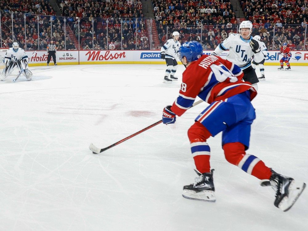 Canadiens' Lane Hutson skates with the puck near the faceoff circle toward the Utah net