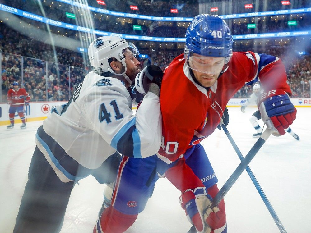 A photo shot through the glass shows Utah's Robert Bortuzzo leaning into the back of the Canadiens' Joel Armia