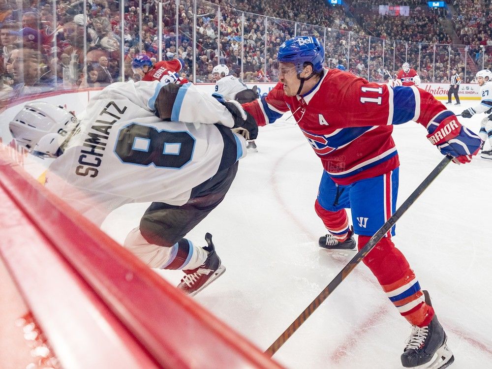 Nick Schmaltz falls to the side toward the boards with Canadiens' Brendan Gallagher grimacing behind him