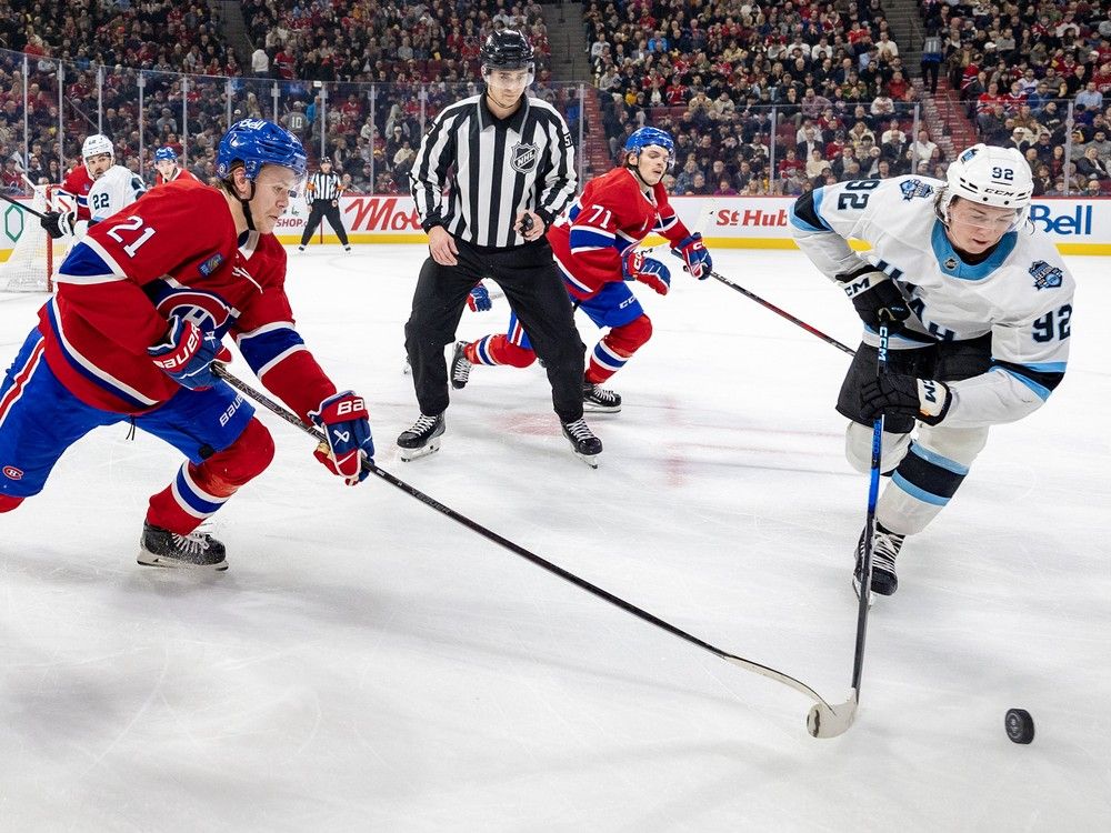 Montreal Canadiens' Kaiden Guhle knocks the puck off the stick of Utah Hockey Club's Logan Cooley