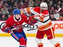 Nazem Kadri #91 of the Calgary Flames holds back Lane Hutson #48 of the Montreal Canadiens during the third period at the Bell Centre on Nov. 5, 2024.