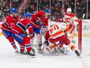 Players pile up as goaltender Sam Montembeault #35 of the Montreal Canadiens covers the puck during the third period against the Calgary Flames at the Bell Centre on Nov. 5, 2024.