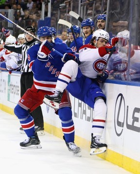 Braden Schneider of the New York Rangers checks Jake Evans of the Montreal Canadiens during the first period at Madison Square Garden on Saturday, Nov. 30, 2024 in New York City.
