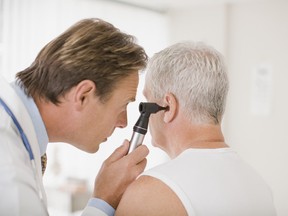Image of a doctor looking into a patient's ear with an otoscope