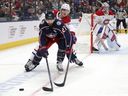 Columbus defenseman Zachary Aston-Reese and Montreal's Justin Barron reach for the puck during second-period NHL action in Columbus, Ohio, Wednesday, Nov. 27, 2024.
