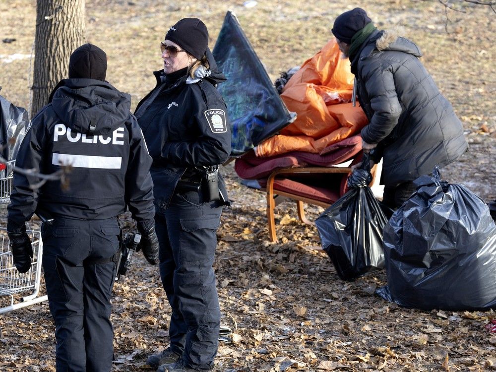 montreal police stand watch as a portion of the notre-dame st. homeless encampment is cleared inside the morgan park fenced boundaries in montreal, dec. 2, 2024. police were not clearing the transport quebec owned lands next to the park area.