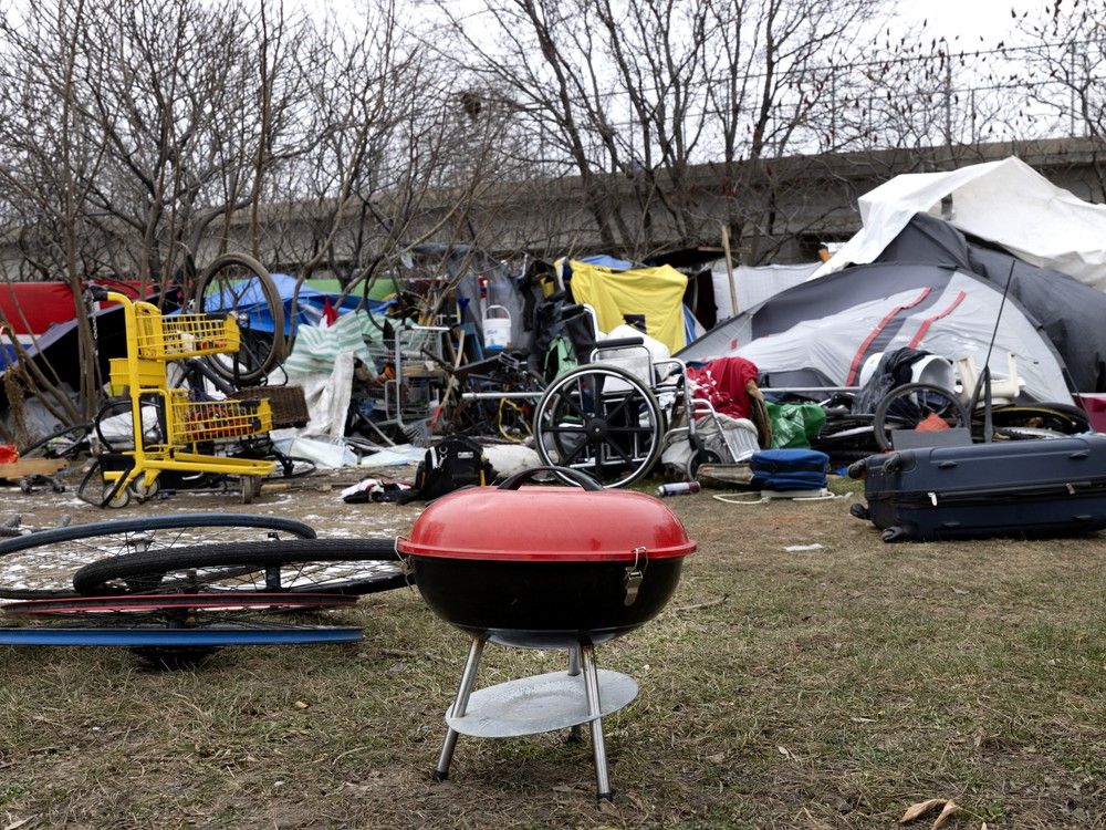  a small barbecue is seen at a safe distance from tents at an encampment on notre-dame st. in montreal on wednesday, dec. 4, 2024.