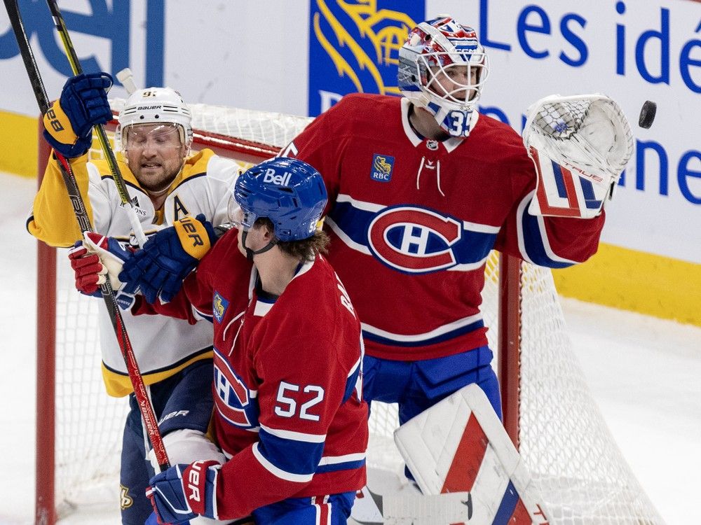 Montreal Canadiens goalie Sam Montembeault makes a glove save as defenceman Justin Barron ties up Nashville Predators' Steven Stamkos