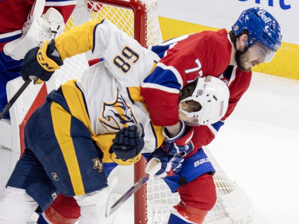 Montreal Canadiens' Kirby Dach puts Nashville Predators' Zachary L'Heureux in a headlock near the net