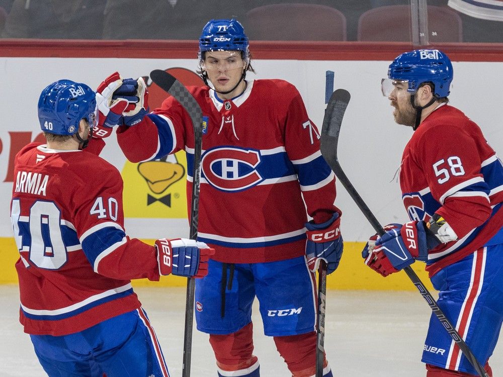 Canadiens Joel Armia, left, and David Savard, right, congratulate Jake Evans with fist bumps on the ice
