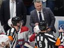 Canadiens coach Martin St. Louis argues with referees Cody Beach, left front, and Francis Charron during the first period of a game against the Colorado Avalanche in March 2024 in Denver.
